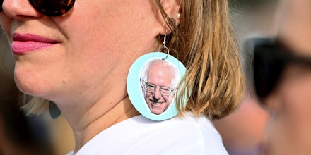 TOPSHOT - A supporter wears earrings with a picture of US Democratic presidential candidate Bernie Sanders as people gather to hear him speak at a rally in the Venice Beach neighborhood of Los Angeles, California, December 21, 2019. (Photo by Robyn Beck / AFP) (Photo by ROBYN BECK/AFP via Getty Images)