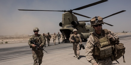 CAMP BOST, AFGHANISTAN - SEPTEMBER 11: U.S. service members walk off a helicopter on the runway at Camp Bost on September 11, 2017 in Helmand Province, Afghanistan. About 300 marines are currently deployed in Helmand Province in a train, advise, and assist role supporting local Afghan security forces. Currently the United States has about 11,000 troops in the deployed in Afghanistan, with a reported 4,000 more expected to arrive in the coming weeks. Last month, President Donald Trump announced his plan for Afghanistan which called for an increase in troop numbers and a new conditions-based approach to the war, getting rid of a timetable for the withdrawal of American forces in the country. (Photo by Andrew Renneisen/Getty Images)