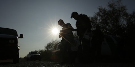 In this Wednesday, Nov. 6, 2019, photo, Border Patrol agents stop men thought to have entered the country illegally, near McAllen, Texas, along the U.S.-Mexico border. In the Rio Grande Valley, the southernmost point of Texas and historically the busiest section for border crossings, the U.S. Border Patrol is apprehending around 300 people daily, down from as many as 2,000 people a day in May. (AP Photo/Eric Gay)
