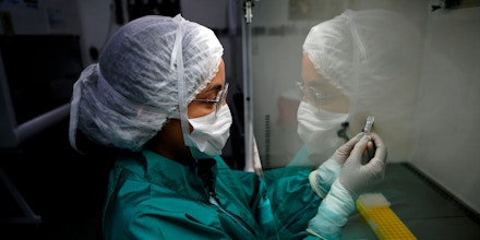 Pesquisadora da Fiocruz, no Rio de Janeiro, segura uma amostra de muco para teste do COVID-19.