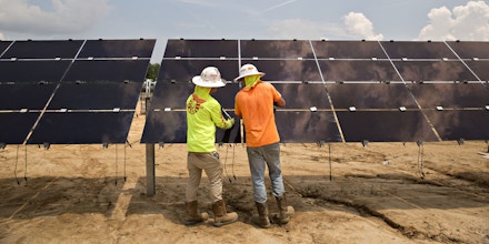 Workers torque mounting brackets on a row of solar panels during construction of a Silicon Ranch Corp. solar generating facility in Milligan, Tennessee, U.S., on Thursday, May 24, 2018. Large oil companies in Europe are continuing to diversify their holdings and increase clean-energy investments. Royal Dutch Shell Plc agreed in January to buy a 44 percent stake in Silicon Ranch Corp., the Nashville-based owner and operator of U.S. solar plants. Photographer: Daniel Acker/Bloomberg via Getty Images