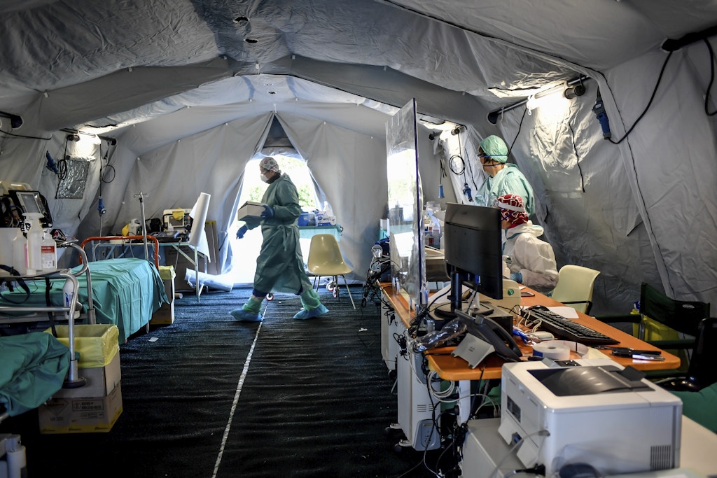 Profissionais da saúde dentro de uma das estruturas de emergência que foram montadas fora de um hospital em Brescia, no norte da Itália, em 10 de março.