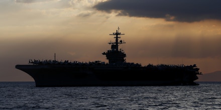 FILE - In this April 13, 2018, file photo the USS Theodore Roosevelt aircraft carrier is anchored off Manila Bay west of Manila, Philippines. The captain of the U.S. Navy aircraft carrier facing a growing outbreak of the coronavirus is asking for permission to isolate the bulk of his roughly 5,000 crew members on shore, which would take the warship out of duty in an effort to save lives. The ship is docked in Guam (AP Photo/Bullit Marquez, File)