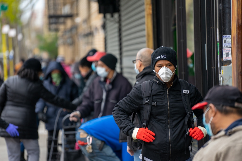 NEW YORK, NY - APRIL 23: Members of the community wait in line for meals to be distributed at the Bronx Draft House on April 23, 2020, in the Bronx borough of New York City. Bronx Draft House is serving free daily lunch to first responders on the front lines of the coronavirus (COVID-19) pandemic as well as assisting World Central Kitchen to distribute free meals to people in vulnerable situations in the community. (Photo by David Dee Delgado/Getty Images)