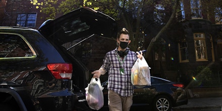WASHINGTON,DC-APR6: Matt Gillette, a 36 year-old Instacart shopper, makes a grocery delivery in Washington, DC, April 6, 2020. For the past two years he's been part of the gig economy, driving for Lyft, doing handiwork on TaskRabbit. The work was so unstable he's been on the verge of homelessness, crashing with some friends and asking others to take in his beloved dog, a lab mix named Nitro.For years there has been talk of a divided America, of an economy that's highly beneficial to some and detrimental to others. The wrath of a highly contagious, sometimes lethal virus has shown us where, precisely, it stands: at the front door. On one side are people who have the luxury of staying safely at home, working -- or not -- and ordering whatever they want to be delivered. On the other side are those doing the delivering. (Photo by Evelyn Hockstein/For The Washington Post via Getty Images)