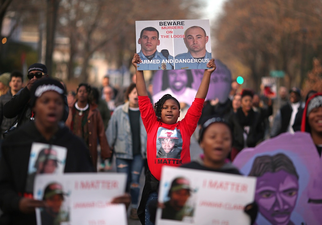 A niece of Jamar Clark protested with a photograph of the two Minneapolis Police that were involved in Clark‚Äôs death. Family members, friends and activists marched too the spot where Jamar Clark was killed in a confrontation with city police last fall to commemorate his death Tuesday October 15, 2016 in Minneapolis, MN.]  Jerry Holt / jerry. Holt@Startribune.com(Photo By Jerry Holt/Star Tribune via Getty Images)