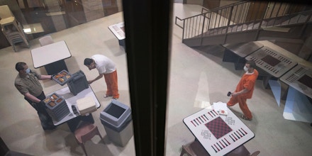 DULUTH, MN - APRIL 28: New inmates in an observation cell block exited their cell one or two at a time and donned face masks to receive their lunch trays at St. Louis County jail on Tuesday. The St. Louis County jail population has fallen dramatically as fewer arrests are made, which has helped keep a COVID-19 outbreak at bay inside the prison. (Photo by Alex Kormann/Star Tribune via Getty Images)