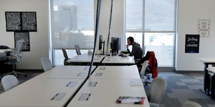 In this Jan. 9, 2019 photo, Facebook employees are seen at their stations during a tour of its new 130,000-square-foot offices, which occupy the top three floors of a 10-story Cambridge, Mass. building. The space gives the company room to triple its current local staff of more than 200. The Silicon Valley company, created by Mark Zuckerberg when he was two subway stops away at Harvard University, opened its first Boston office five years ago. (AP Photo/Elise Amendola)