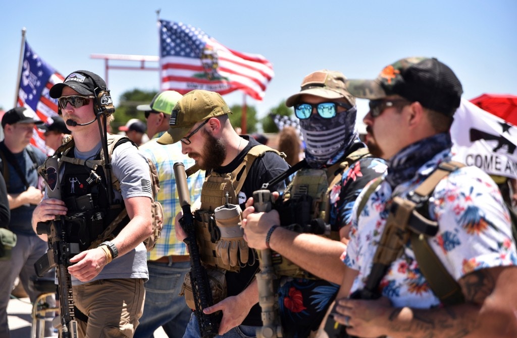 Open Carry Texas protesters, some sporting jolly roger patches and Hawaiian shirts, prepare to pose for a group photo outside of the bar Big Daddy Zane's, Saturday, June 6, 2020 in Odessa, Texas. Following the arrest of the bar owner and six armed protesters defending the bar's opening in early May, Open Carry Texas had called for a rally to be held outside the bar as a way to respond to the event. (Eli Hartman/Odessa American via AP)