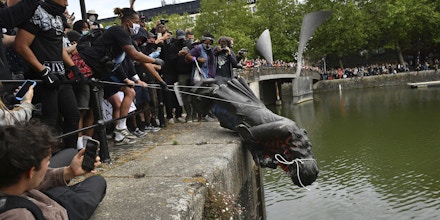 Black Lives Matter protests. Protesters throw statue of Edward Colston into Bristol harbour during a Black Lives Matter protest rally, in memory of George Floyd who was killed on May 25 while in police custody in the US city of Minneapolis. Picture date: Sunday June 7, 2020. See PA story POLICE Floyd. Photo credit should read: Ben Birchall/PA Wire URN:54052046 (Press Association via AP Images)