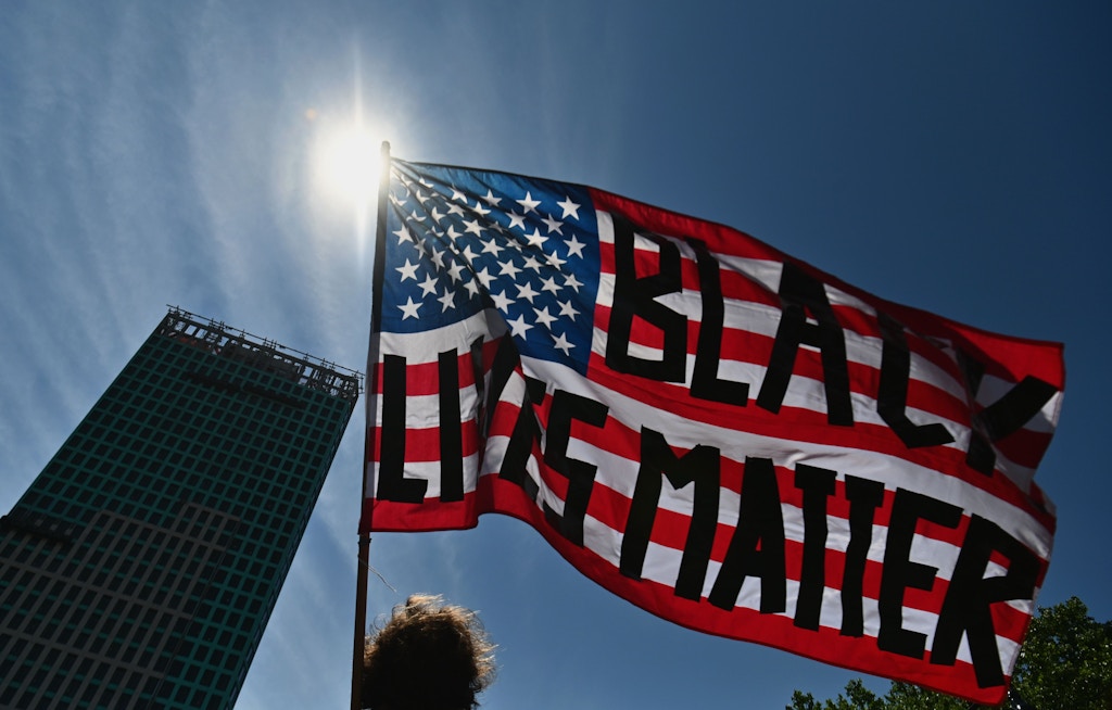 A protestor waves an American flag with the words "Black Lives Matter" painted on it during a Juneteenth rally at Cadman Plaza on June 19, 2020 in the Brooklyn Borough of New York City. - The US marks the end of slavery by celebrating Juneteenth, with the annual unofficial holiday taking on renewed significance as millions of Americans confront the nation's living legacy of racial injustice. (Photo by Angela Weiss / AFP) (Photo by ANGELA WEISS/AFP via Getty Images)