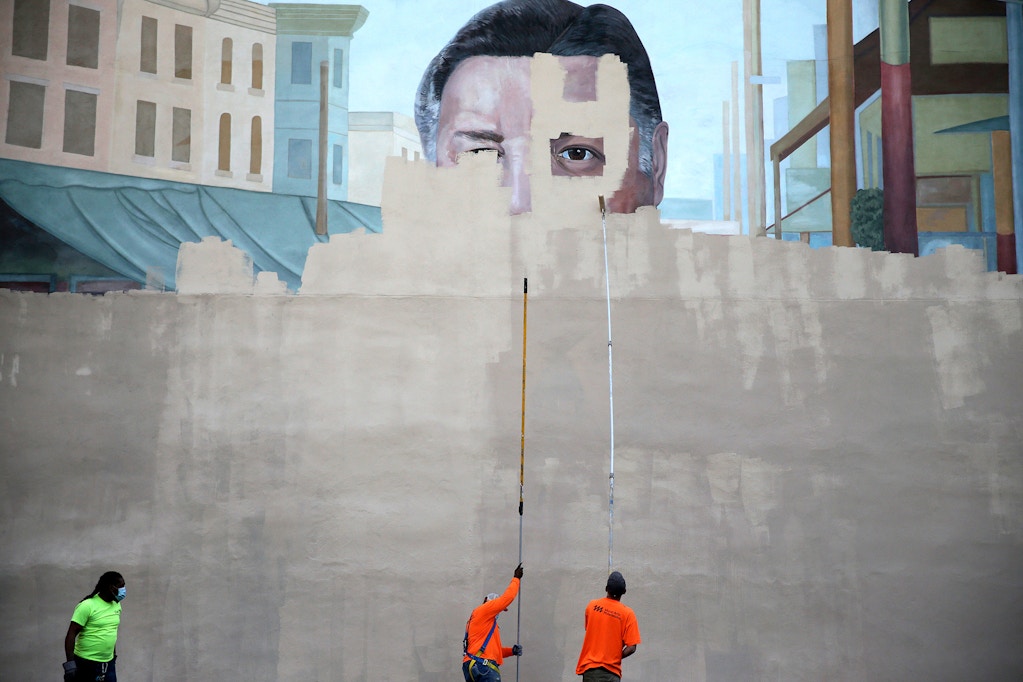 A crew from Mural Arts paints over the Frank Rizzo mural on 9th Street in Philadelphia
