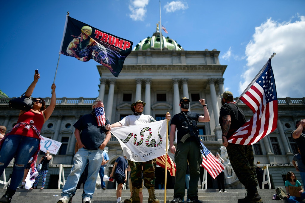 Trump supporters and a man with an assault rifle join demonstrators outside the Pennsylvania Capitol Building to protest the continued closure of businesses due to the coronavirus pandemic