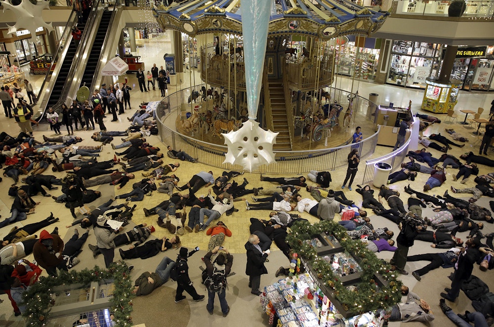 Protesters stage a "die in" inside Chesterfield Mall, Friday, Nov. 28, 2014, in Chesterfield, Mo. The crowd disrupted holiday shopping at several locations on Friday amid a protest triggered by a grand jury's decision not to indict the police officer who fatally shot Michael Brown in nearby Ferguson. (AP Photo/Jeff Roberson)