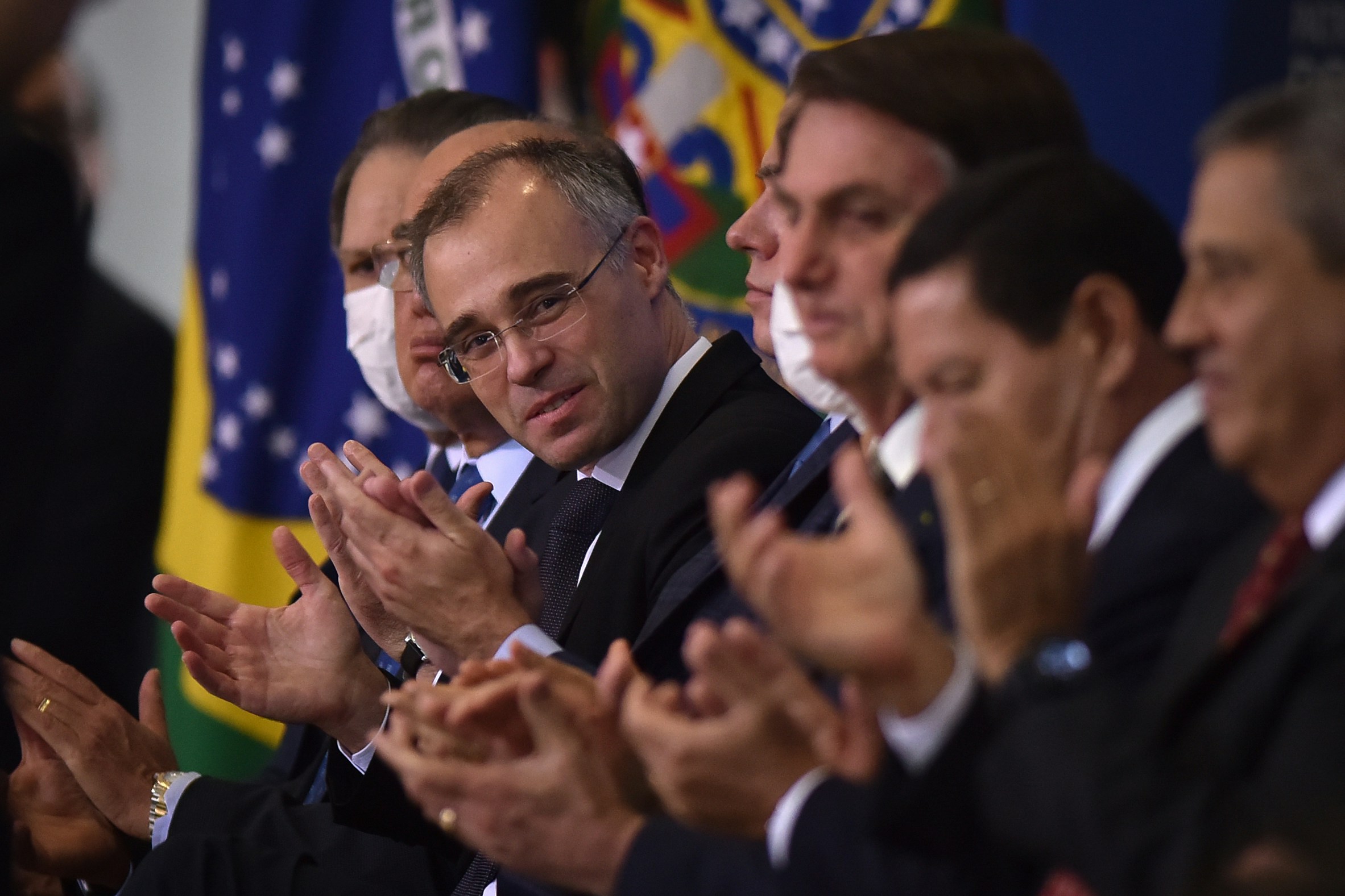 Andre Mendonca, Brazil's new minister of justice, center, applauds during an inauguration ceremony with Jair Bolsonaro, Brazil's president, at Planalto Palace in Brasilia, Brazil, on Wednesday, April 29, 2020. Medonca is taking over after Sergio Moro quit the post following Bolsonaro's firing of the federal police chief. Photographer: Andres Borges/Bloomberg via Getty Images