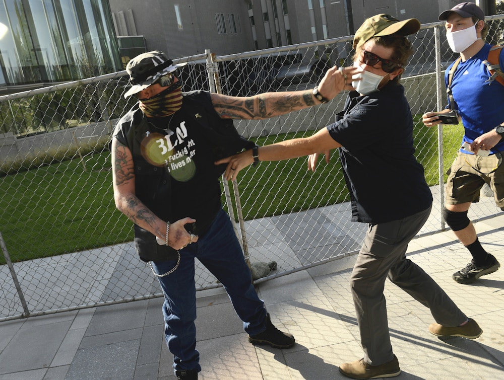 DENVER, COLORADO - OCTOBER 10: A man punches another man after a rall in Denver, Colorado, on October 10, 2020. The man on the left side of the photo was supporting the "Patriot Rally". He engaged with the man on the right, hit him in the face and sprayed him with mace. The man at right, then shot and killed the protester at left. At the time two rallies, one right-wing and another left-wing, were taking place near one another. Denver Channel 9News has confirmed that the man who did the shooting was a private security guard contracted by them and is in custody after the shooting. It has been confirmed the guard was contracted through Pinkerton for the station. (Photo by Helen H. Richardson/MediaNews Group/The Denver Post via Getty Images)