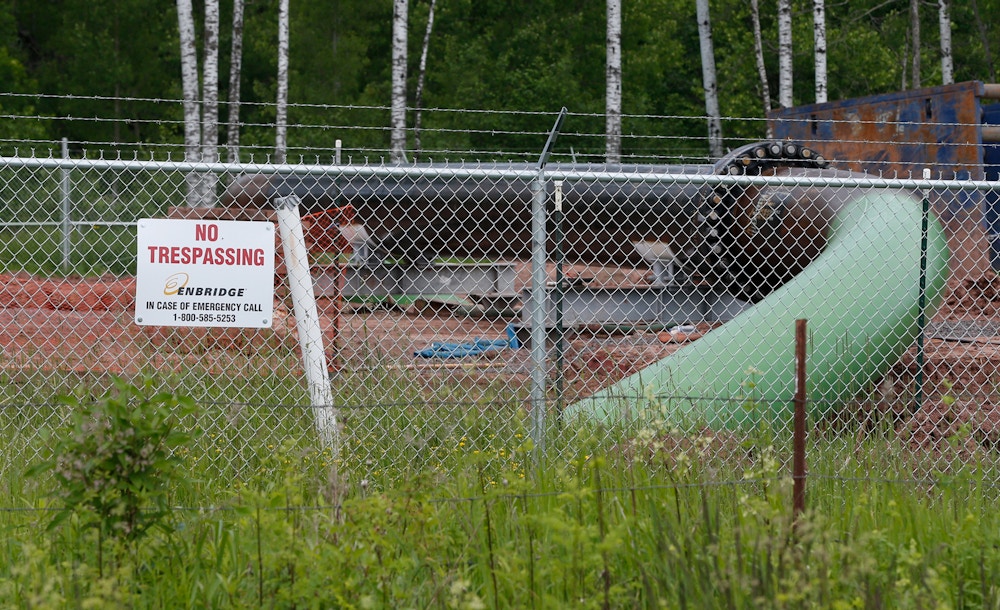 FILE - In this June 29, 2018 file photo, a No Trespassing sign is visible at a Enbridge Energy pipeline drilling pad along a rail line that traces the Minnesota-Wisconsin border south of Jay Cooke State Park in Minnesota. Gov. Tim Walz says his administration will continue to appeal a regulatory commission's approval of Enbridge Energy's plan to replace its aging Line 3 crude oil pipeline. The commission approved the project last summer, but former Gov. Mark Dayton's Department of Commerce appealed that decision, as did several environmental and tribal groups. An appeals court decision last week sent the challenges back to the commission for further proceedings. (AP Photo/Jim Mone)