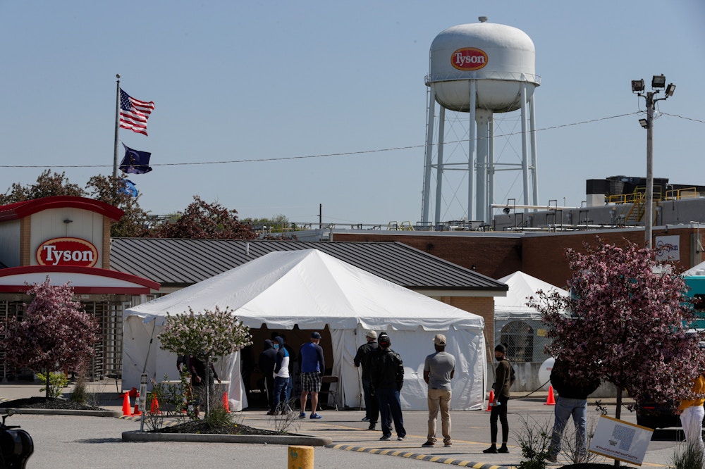 Workers wait in line to enter the Tyson Foods pork processing plant in Logansport, Ind., Thursday, May 7, 2020. The plant was expected to Thursday after closing on April 25 after nearly 900 employees tested positive for the coronavirus. Workers won't be able to return to work until they get tested. (AP Photo/Michael Conroy)