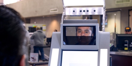 A pedestrian crossing from Mexico into the United States at the Otay Mesa Port of Entry has his facial features and eyes scanned at a biometric kiosk Thursday, Dec. 10, 2015, in San Diego.  On Thursday, U.S. Customs and Border Protection began capturing facial and eye scans of foreigners entering the country at San Diego's Otay Mesa port of entry on foot.  (AP Photo/Denis Poroy)