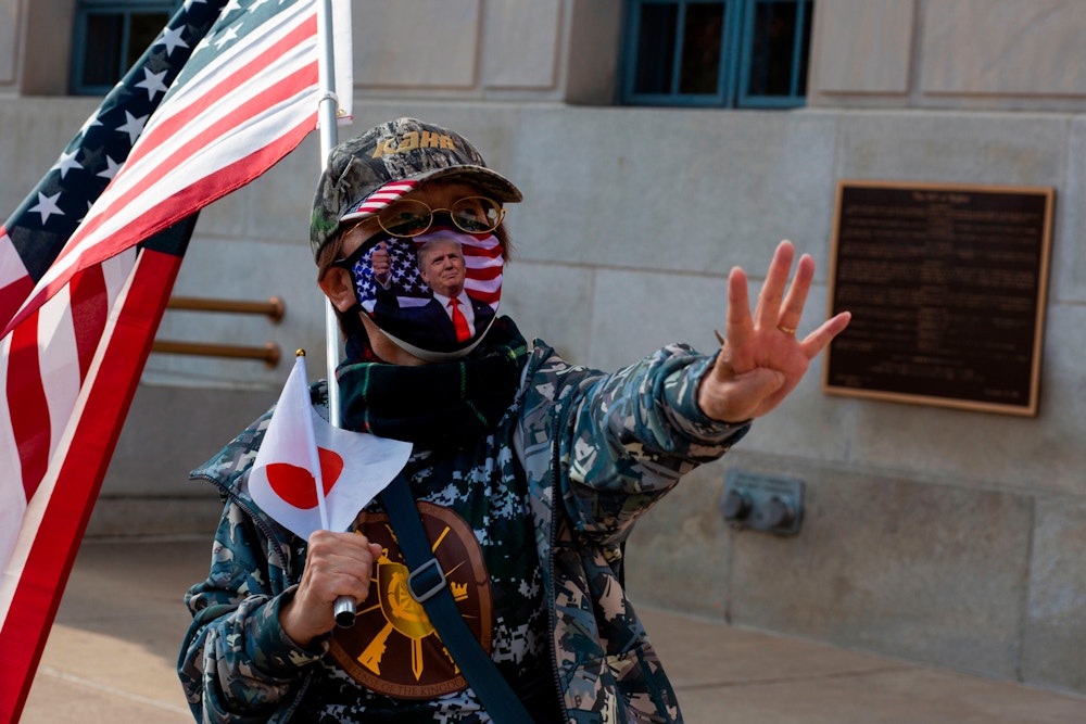 A Trump Supporter from Japan gesture as a group gathers to show support for the President on October 23, 2020 in Scranton, Pennsylvania. - In the city center, about twenty Japanese people in red "MAGA" caps waving Republican flags and distributing leaflets calling for a vote for the president. If they are greeted by many enthusiastic honks of the horn, some onlookers shout their disapproval. (Photo by Kena Betancur / AFP) (Photo by KENA BETANCUR/AFP via Getty Images)