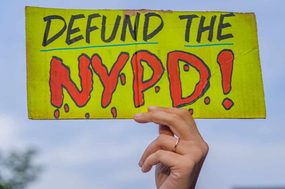 BROOKLYN, NEW YORK, UNITED STATES - 2020/08/28: A participant holding a Defund NYPD sign at the protest. A coalition of activists and organizations led by activist, poet, and organizer Selu gathered across New York City. The coalition of NYC-based activists and organizations participated on a march through NYC in solidarity with the Get Your Knee Off Our Necks Commitment March on Washington to amplify the movement against police brutality and racial injustice. (Photo by Erik McGregor/LightRocket via Getty Images)