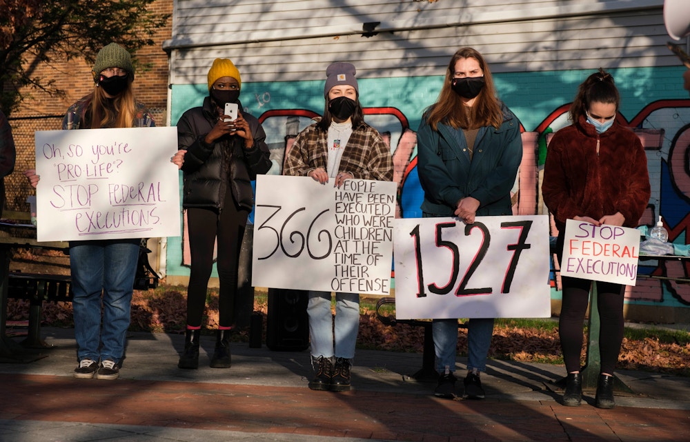 BLOOMINGTON, INDIANA, UNITED STATES - 2020/12/04: College students and community members wearing face masks hold placards while gathering in Peoples Park to protest against the death penalty, and a wave of executions at the Terre Haute federal prison (Federal Correctional Complex at Terre Haute) during the last months of Donald J. Trump's presidency.  The federal government has already executed 8 prisoners on death row, and several more are scheduled to be put to death before January 20th. Billie Allen, who maintains his innocence, but is on death row, spoke to the group via a phone call from prison. (Photo by Jeremy Hogan/SOPA Images/LightRocket via Getty Images)