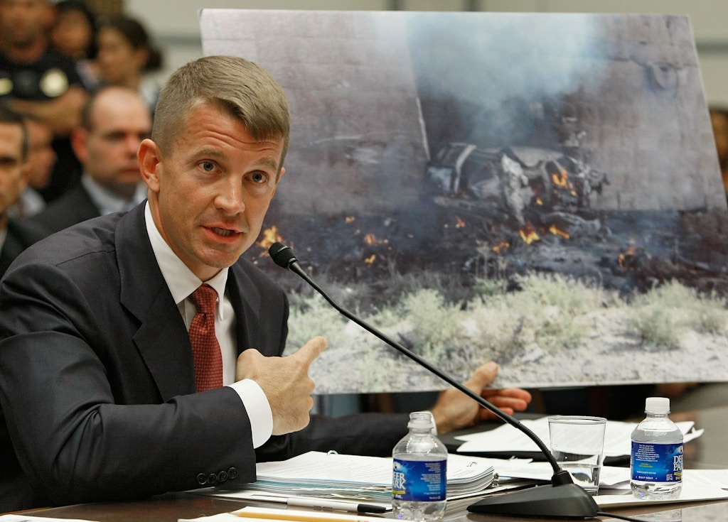 Erik Prince, chairman of the Prince Group, LLC and Blackwater USA, holds up a picture showing the affect of a car bomb while testifying during a House Oversight and Government Reform Committee hearing on Capitol Hill October 2, 2007 in Washington DC.