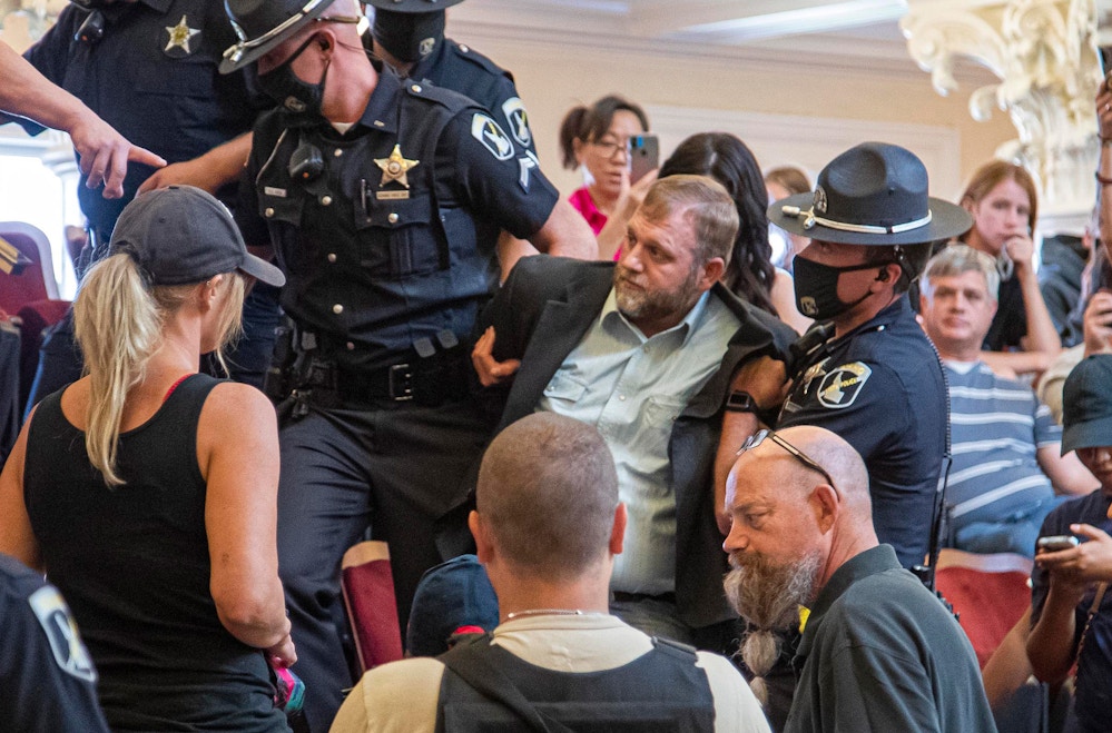 Ammon Bundy is dragged from the Idaho Senate Chambers gallery by Idaho State Troopers after returning to the Idaho Statehouse Wednesday, Aug. 26, 2020 in Boise. Officers cited a statute before taking Bundy into custody a day after being arrested for refusing to leave a committee meeting. (Darin Oswald/Idaho Statesman via AP)
