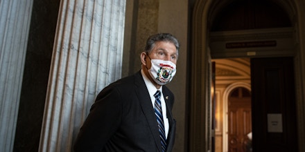 Senator Joe Manchin, a Democrat from West Virginia, wears a protective mask as he waits in line to vote for a Democratic caucus rules change at the U.S. Capitol in Washington, D.C., U.S., on Wednesday, Dec. 9, 2020. Treasury Secretary Mnuchin made a surprise re-entry into talks on a 2020 pandemic-relief package with a $916 billion proposal that opened a potential new path to a year-end deal despite objections from Democrats over elements of the plan. Photographer: Al Drago/Bloomberg via Getty Images