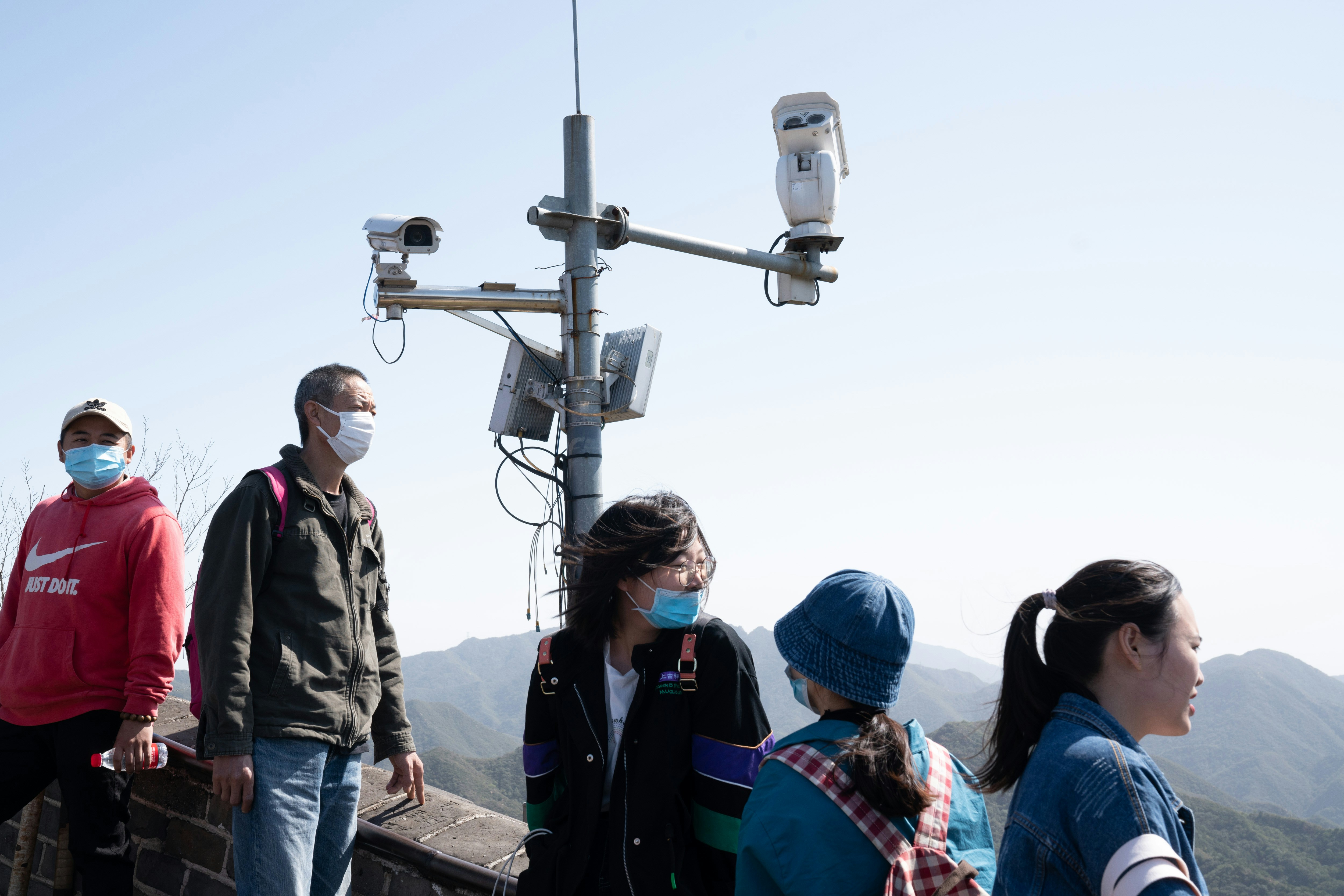 Visitors stand near surveillance cameras at the Badaling section of the Great Wall in Beijing, China, on Oct. 1, 2020.