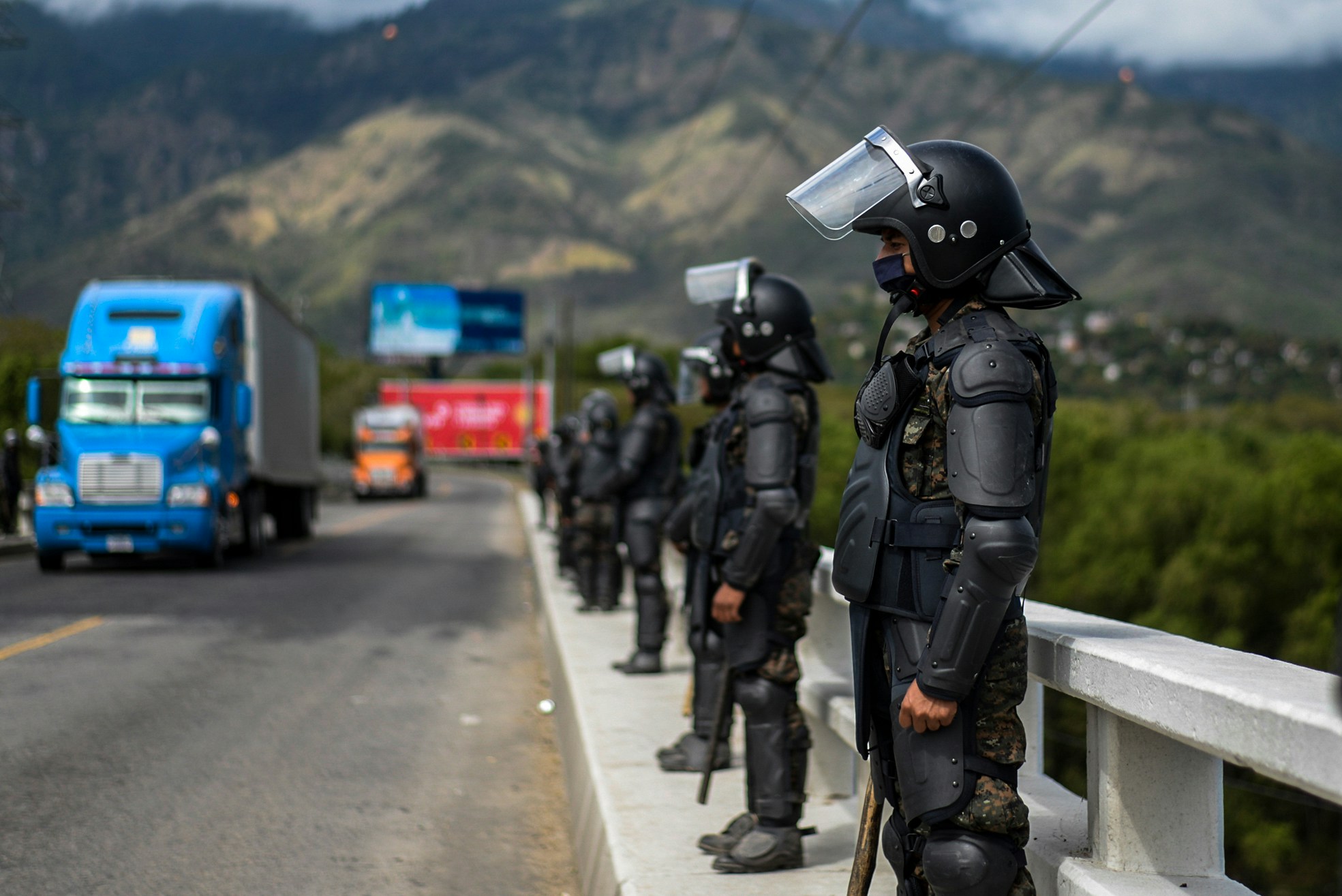 Members Guatemalan Army stand guard at a bridge in Zacapa, Guatemala on January 19, 2021. - On buses and trucks, Guatemala transported Tuesday several groups of migrants who were part of a US-bound caravan back to Honduras, after police and military officers forced them to desist from the crossing. (Photo by Johan ORDONEZ / AFP) (Photo by JOHAN ORDONEZ/AFP via Getty Images)