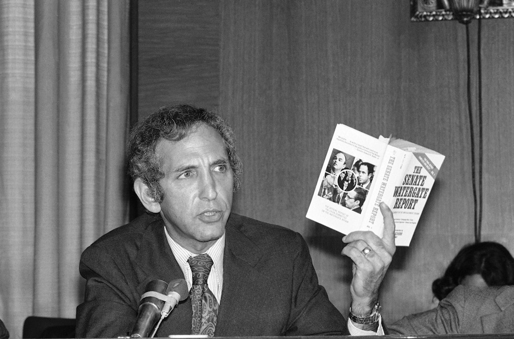 Daniel Ellsberg, the Pentagon Papers figure, holds up a copy of a book entitled ?The Senate Watergate Report? as he appears as a panelist at a conference on the Central Intelligence Agency and covert activities on Friday, Sept. 13, 1974 in Washington. (AP Photo/Henry Griffin)