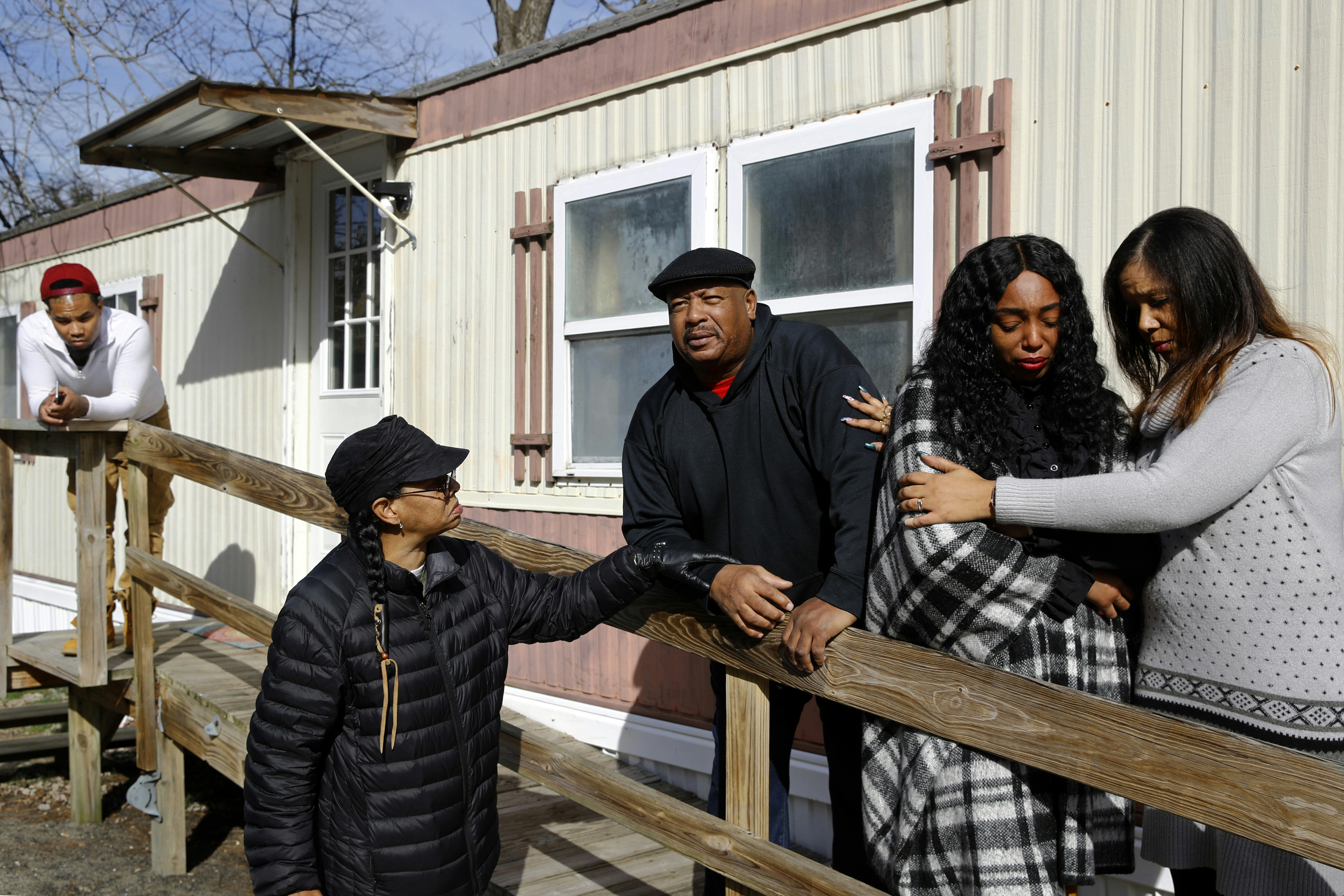 In this Jan. 28, 2019, photo, Brandon Jackson, from far left, Kym Lofland, Antone Black, Monique Sorrell and LaToya Holley stand on a ramp where a struggle among their family member Anton Black and three police officers and a civilian occurred before his death outside the home in Greensboro, Md. The family isn't satisfied by the conclusions of a county prosecutor, who isn't pursuing criminal charges in Black's death, or the medical examiner who ruled it accidental. They're calling for a federal investigation and appealing for help from Gov. Larry Hogan, who already has expressed a personal interest in the case. (AP Photo/Patrick Semansky)