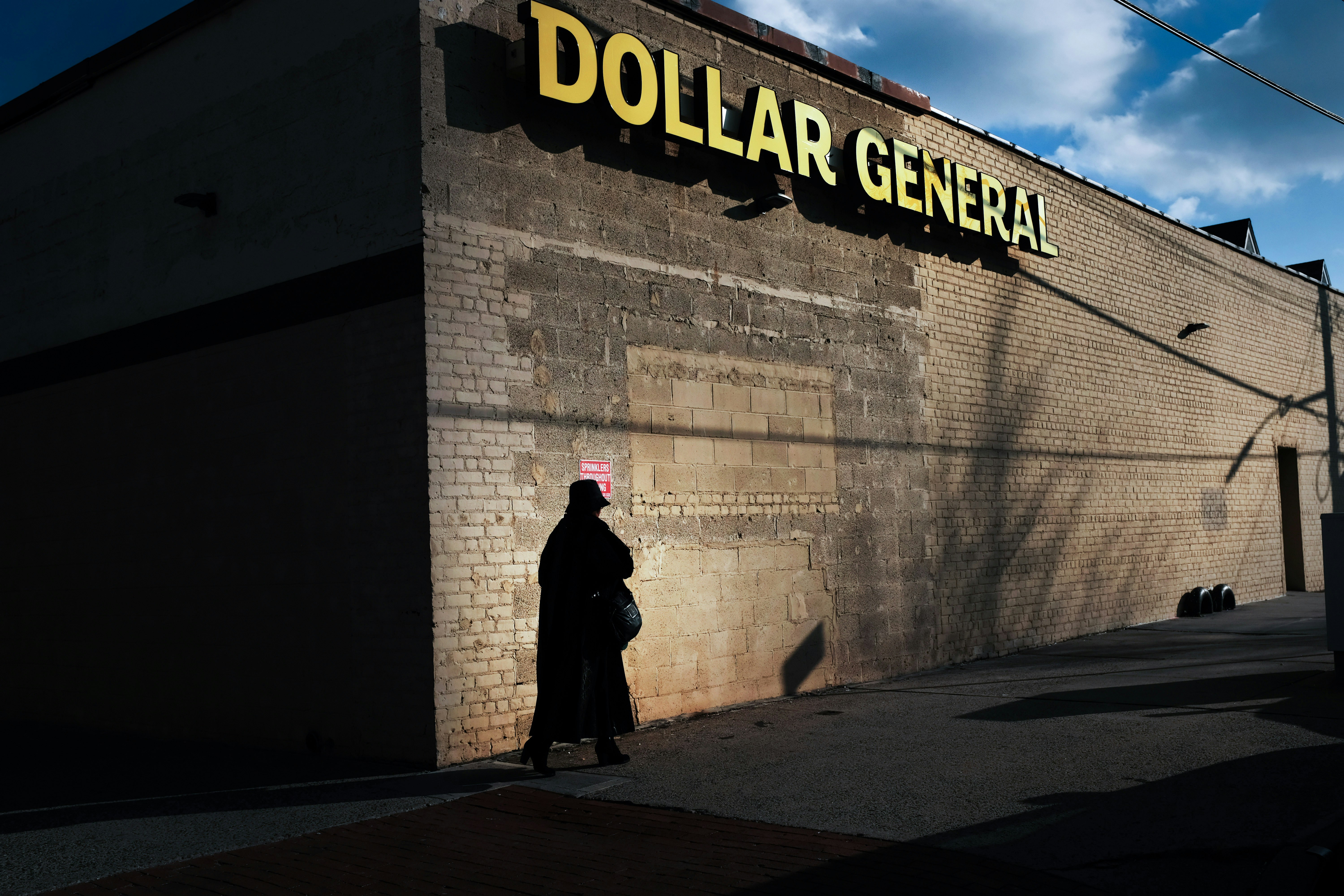 A woman walks by a Dollar General store on December 11, 2018 in the Brooklyn borough of New York City.
