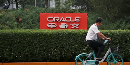 A cyclist rides past a signage displayed outside Oracle Building at Zhongguancun Software Park on August 30, 2020 in Beijing, China.