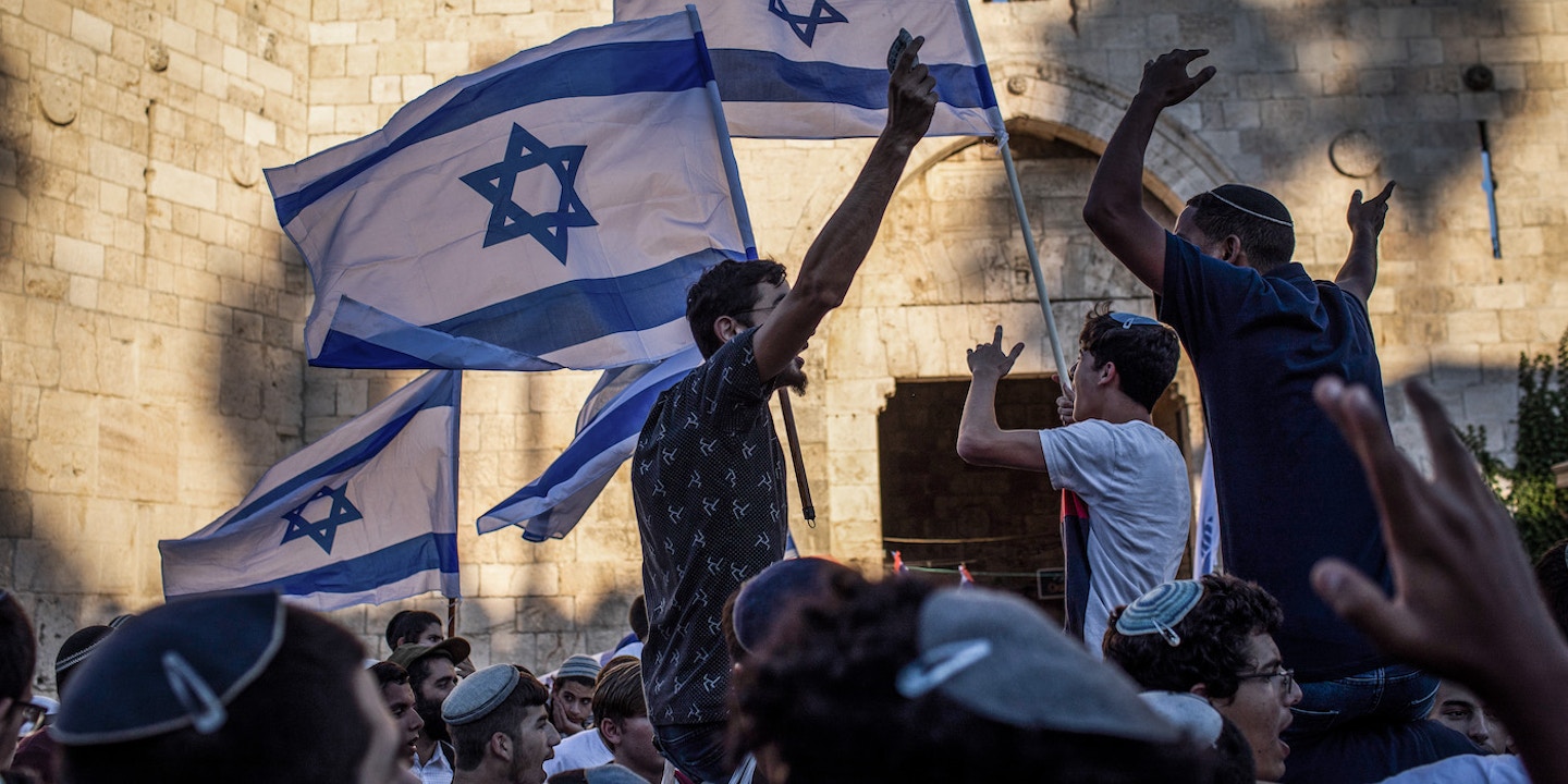 15 June 2021, Israel, Jerusalem: People gather at the Damascus Gate of the Old City of Jerusalem with flags of Israel during the controversial Flag March, organized by Israeli right-wing nationalists. Photo: Ilia Yefimovich/dpa (Photo by Ilia Yefimovich/picture alliance via Getty Images)