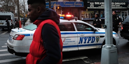 NEW YORK, NEW YORK - NOVEMBER 18: People walk past a police car in the in the Brownsville neighborhood of Brooklyn on November 18, 2019 in New York City. As former New York City Mayor Michael Bloomberg inches closer to running for president in 2020, he has formally apologized for his controversial “stop and frisk” policy that created distrust and fear of police in black and Latino communities during his administration. The Brownsville section of Brooklyn saw some of the highest numbers of incidents where young men were routinely stopped, searched and questioned by police.  (Photo by Spencer Platt/Getty Images)