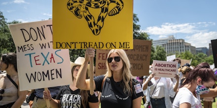 AUSTIN, TX - MAY 29: Protesters hold up signs at a protest outside the Texas state capitol on May 29, 2021 in Austin, Texas. Thousands of protesters came out in response to a new bill outlawing abortions after a fetal heartbeat is detected signed on Wednesday by Texas Governor Greg Abbot. (Photo by Sergio Flores/Getty Images)