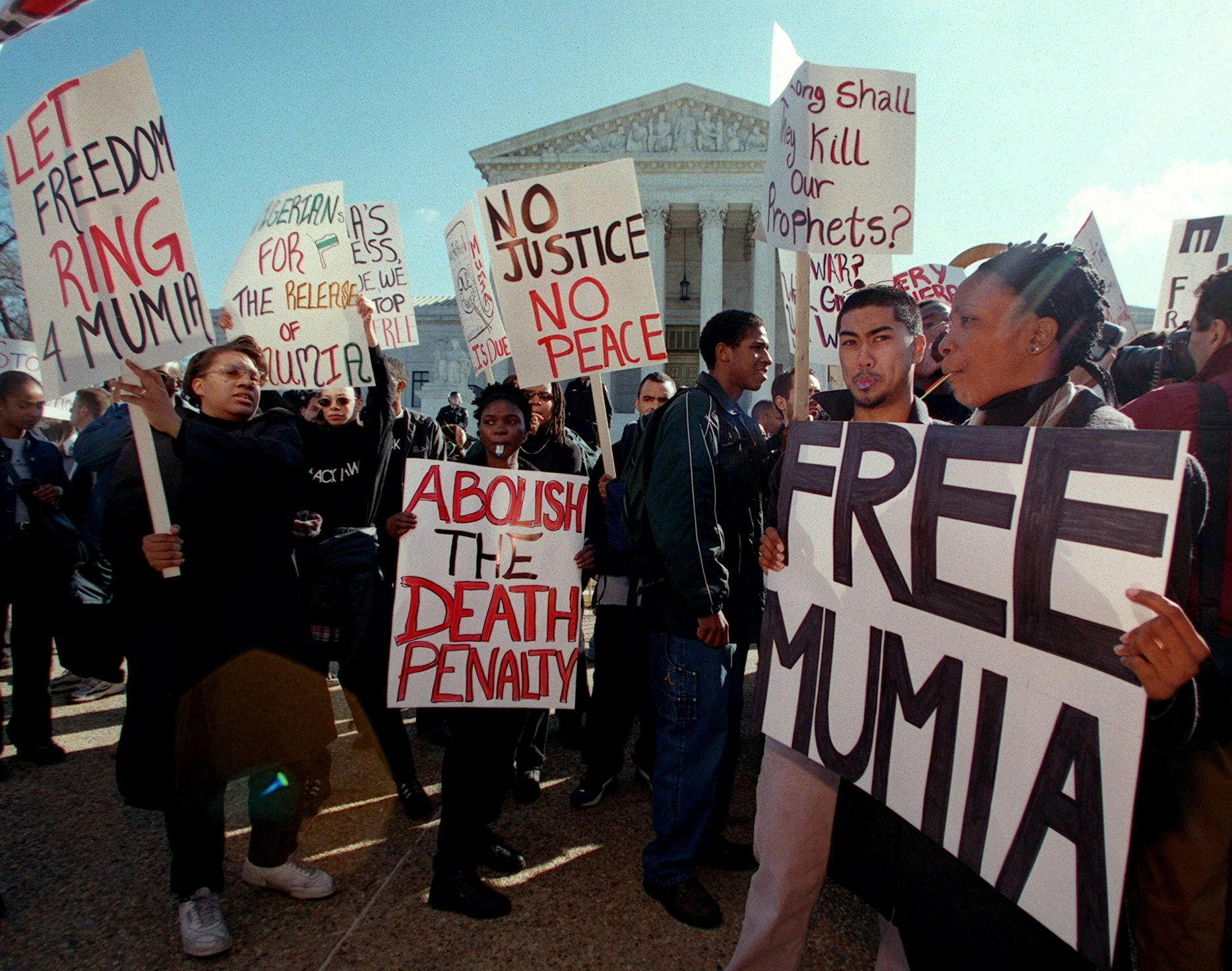 WASHINGTON, :  Protesters march with signs calling for the end of the death penalty during a demonstration 28 February, 2000 in front of the US Supreme Court in Washington, DC, as justices inside the Supreme Court hear arguments on the Effective Death Penalty Act of 1996, giving the right to appeal when there is new evidence of innocence. The protesters are seeking a new trial for former radio journalist and one time Black Panther Mumia Abu-Jamal who was sentenced to death for killing a Philadelphia police officer in 1981.    AFP PHOTO/Chris KLEPONIS (Photo credit should read CHRIS KLEPONIS/AFP via Getty Images)
