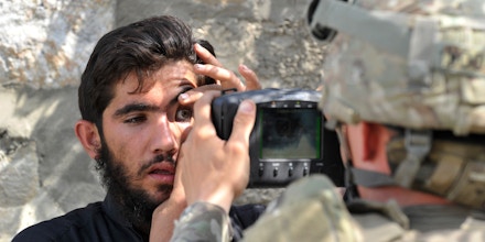 Um soldado do exército dos EUA examina os olhos de um afegão com um Sistema Automatizado de Identificação Biométrica durante uma missão em Turkham, no Afeganistão, em 6 de outubro de 2011.