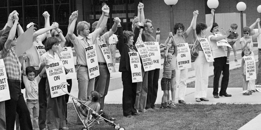Members of PATCO, the air traffic controllers union, hold hands and raise their arms as their deadline to return to work passes. All strikers were fired on the order of President Reagan on August 5, 1981.