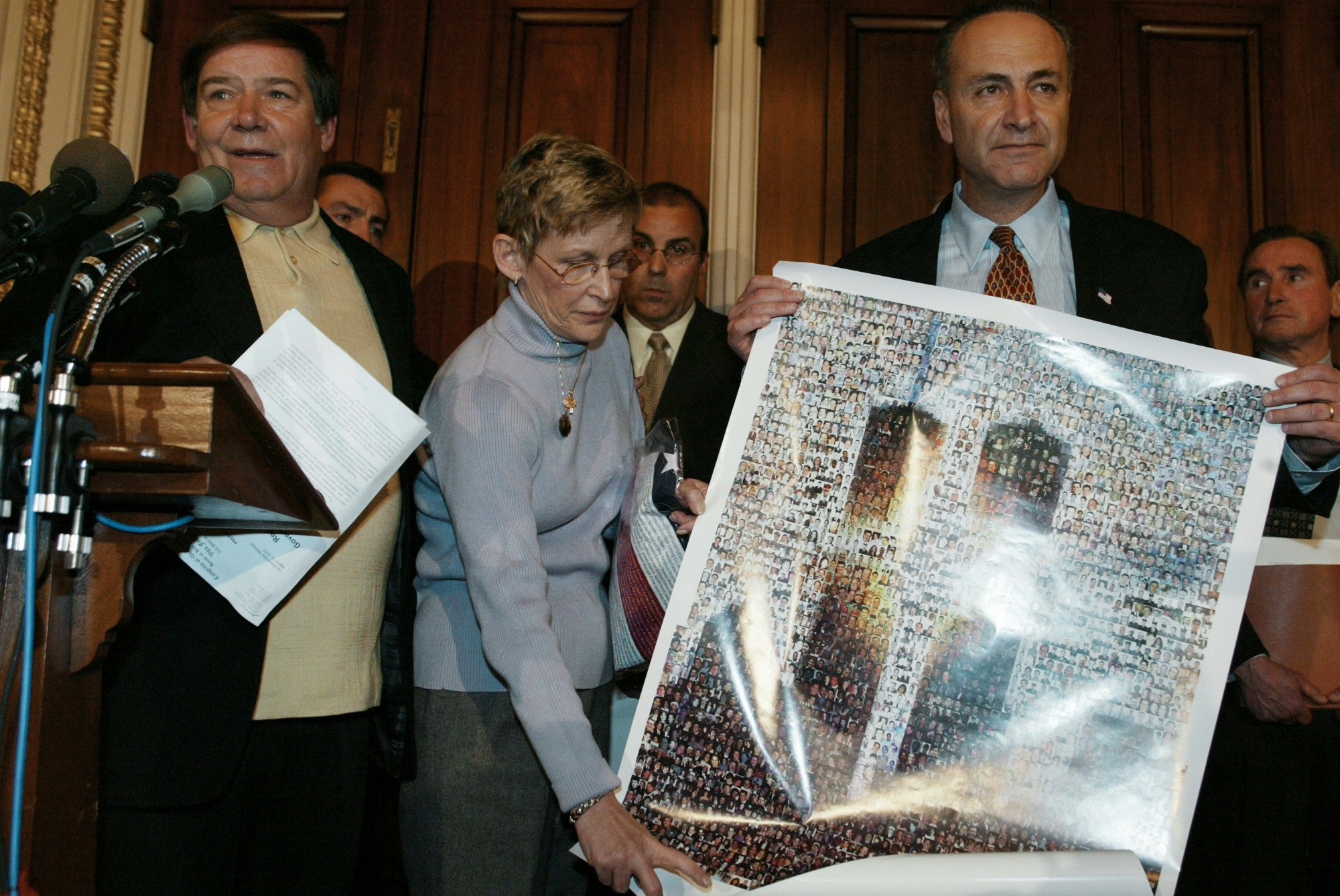 Bill Doyle, left, and Joan Molinaro, center, both from Staten Island, N.Y., parents of victims, present a poster of the World Trade Center bearing photographs of all the victims of the Sept. 11 terrorist attacks to Senator Charles Schumer, D-N.Y., during a news conference on terrorist financing on Capitol Hill Wednesday, March 19, 2003. Schumer said that new documents in possession by the Justice Department linking some of Saudi Arabia's most influential families to Al Qaeda should be made available tohelp victims' families prosecute those responsible for the Sept. 11 tragedy. Man rear center is John D'Amato, and rear right is Ronald Motley, attorney for the Sept. 11 families of victims. (AP Photo/Charles Dharapak)