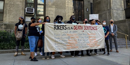 Advocates hold a sign showing the names of incarcerated men who died at Rikers Island jail complex outside the New York City Criminal Court in Manhattan, N.Y. on Sept. 27, 2021.