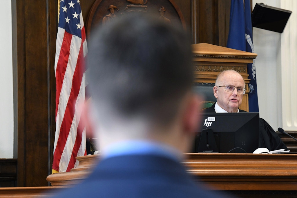 Circuit Court Judge Bruce Schroeder presides over a pre-trial hearing for Kyle Rittenhouse, foreground, at the Kenosha County Courthouse in Kenosha, Wis., on Monday, Oct. 25, 2021. Schroeder laid out the final ground rules on what evidence will be allowed when Rittenhouse goes on trial for killing two people and wounding a third during a protest against police brutality in August 2020. (Mark Hertzberg/Pool Photo via AP)