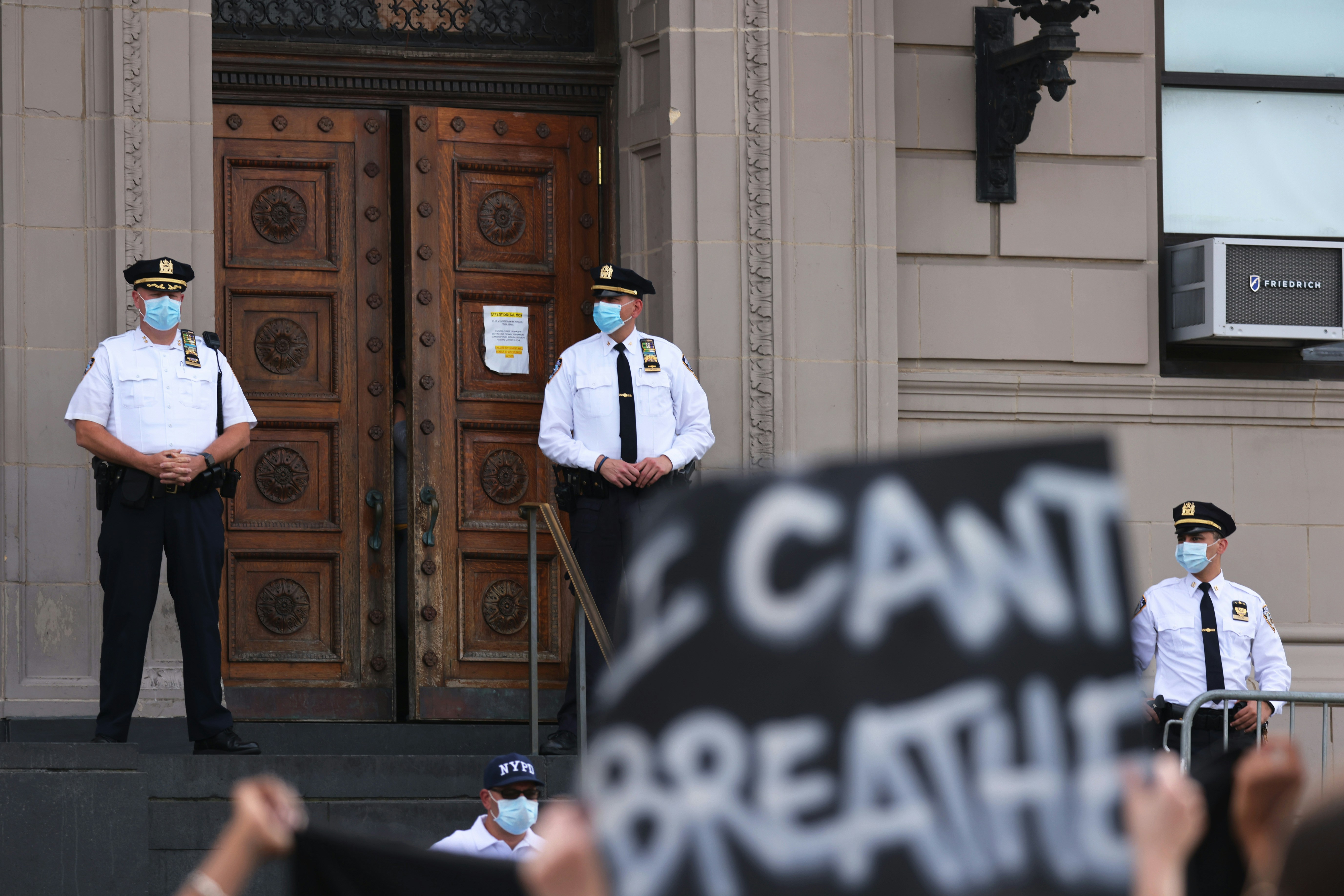 NEW YORK, NEW YORK - JULY 17: Police officers stand guard as protesters gather in front of the 120th NYPD precinct on the sixth anniversary of Eric Garner's death in Tompkinsville, Staten Island on July 17, 2020 in New York City. Garner was killed after being placed in a chokehold by former New York City Police officer Daniel Pantaleo during an arrest in 2014. (Photo by Michael M. Santiago/Getty Images)