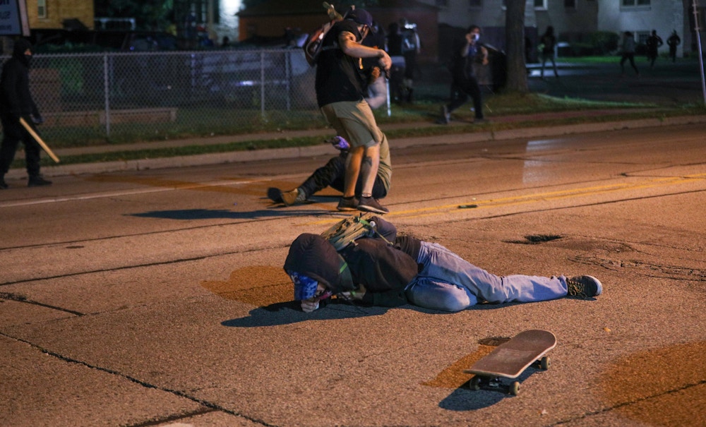 KENOSHA, WISCONSIN, USA - AUGUST 25: (EDITORS NOTE: Image contains graphic content.) A protester clashes with armed civilian Kyle Rittenhouse as another man lies on the ground having been shot in the chest during confrontations between protesters and armed civilians, who claimed to protect the streets of Kenosha against the arson, during the third day of protests over the shooting of a black man Jacob Blake by police officer in Wisconsin, United States on August 25, 2020. Kyle Rittenhouse has been charged by Wisconsin prosecutors with the killing of Anthony Huber, 26 and Joseph Rosenbaum, 36 and the injuring of Gaige Grosskreutz, also 26. (Photo by Tayfun Coskun/Anadolu Agency via Getty Images)