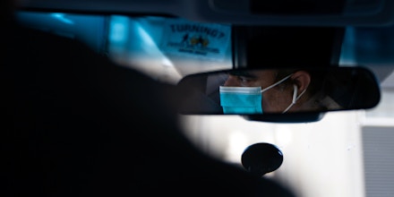 Um motorista da Uber usando uma máscara cirúrgica é visto pelo espelho em Manhattan em 15 de março de 2020.