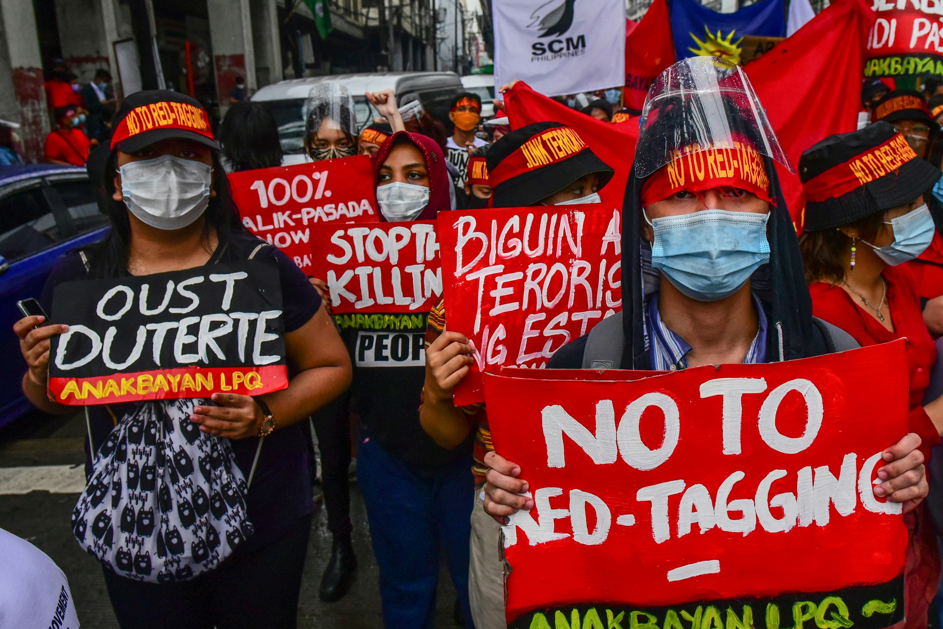 This photo taken on December 10, 2020 shows protesters with slogans against "red-tagging" on their hats and placards as they take part in a protest to commemorate International Human Rights Day near the presidential palace in Manila. - A torrent of misinformation on the social media platform has put activists, journalists, politicians and lawyers in the firing line as President Rodrigo Duterte's government and military out alleged supporters of a decades-old Maoist insurgency. (Photo by maria Tan / AFP) / TO GO WITH Philippines-internet-rights,FOCUS by Cecil Morella and Jake Soriano (Photo by MARIA TAN/AFP via Getty Images)