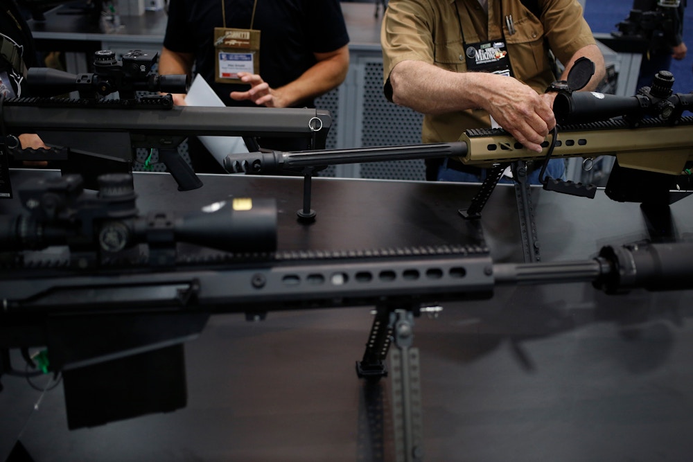Attendees handle Barrett Firearms Manufacturing .50 caliber sniper rifles on the exhibit floor during the National Rifle Association (NRA) annual meeting in Louisville, Kentucky, U.S., on Friday, May 20, 2016. The nation's largest gun lobby, the NRA has been a political force in elections since at least 1994, turning out its supporters for candidates who back expanding access to guns. Photographer: Luke Sharrett/Bloomberg via Getty Images