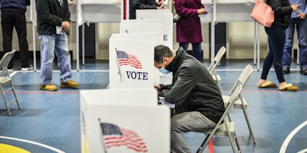 Mitchell Leet, of Chesterfield, N.H., fills out his ballot as a long line of people wait to submit their ballots at the polling station at Chesterfield Elementary School's gymnasium during the 2020 Election on Tuesday, Nov. 3, 2020. (Kristopher Radder/The Brattleboro Reformer via AP)